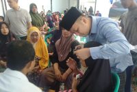 Petugas medis memeriksa kondisi mata salah seorang warga dalam kegiatan bakti sosial pemeriksaan mata dan pembagian kacamata gratis yang digelar Anggota DPR RI Fraksi PAN, H. Slamet Ariyadi, di Kecamatan Camplong, Kabupaten Sampang, Rabu (5/8/2026).