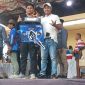 Owner Nyonya Muda Team, Ahmad Anam Syahputra, bersama perawat sapi saat menerima trofi Juara III Golongan Atas Karapan Sapi Piala AHY 2026 di Stadion Karapan Sapi R.P. Moeh Noer, Kabupaten Bangkalan.