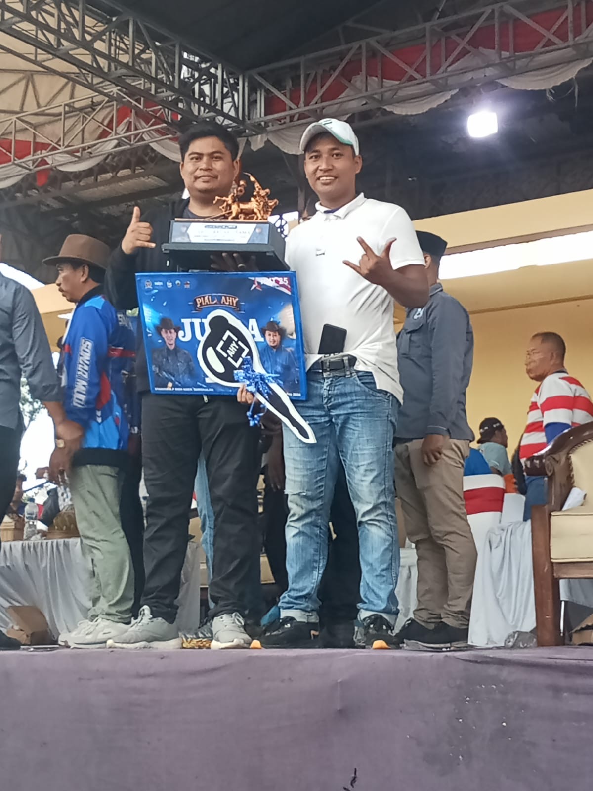 Owner Nyonya Muda Team, Ahmad Anam Syahputra, bersama perawat sapi saat menerima trofi Juara III Golongan Atas Karapan Sapi Piala AHY 2026 di Stadion Karapan Sapi R.P. Moeh Noer, Kabupaten Bangkalan.