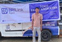 AGEN BRILINK. Fauzi di depan tempat usahanya, Agen BRILink Toko Fauzi Angkatan, Desa Angkatan, Pulau Kangean, Sumenep. Usaha ini melayani kebutuhan transaksi keuangan warga di wilayah kepulauan. (istimewa/redaksi ejaberita.co)